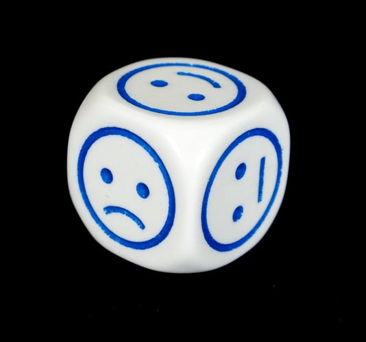 faces with different emotions on dice with black background